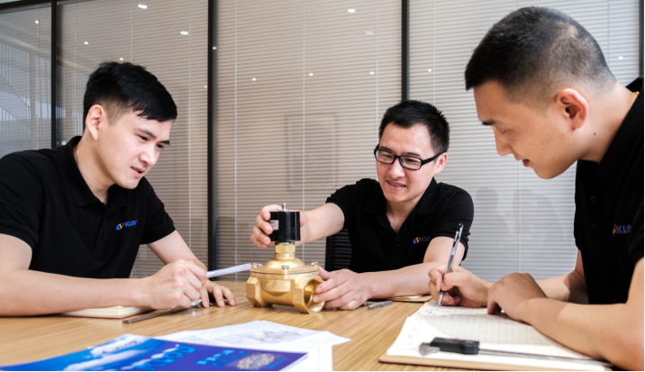 Kailing engineers reviewing a solenoid valve and technical drawing